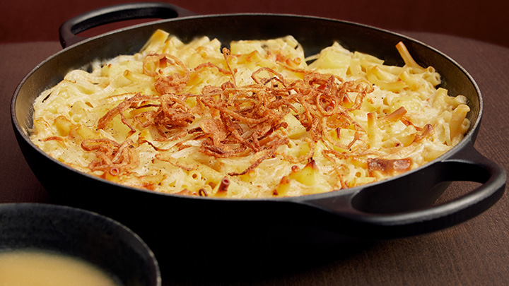 Maccheroni di formaggio con salsa di mele e cipolle fritte